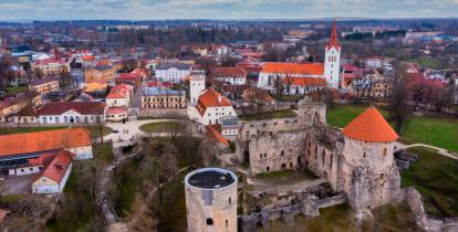 Widok z lotu ptaka miasta ze starą zabudową, na pierwszym planie budowla sakralna z wysoką wieżą, w tle widoczne fragmentu budowli zamkowej