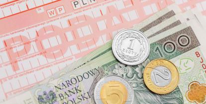 Druk przelewu podatku, na którym leżą banknoty i monety o różnych nominałach.