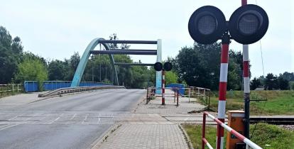 Przejazd kolejowy. W widać most. 