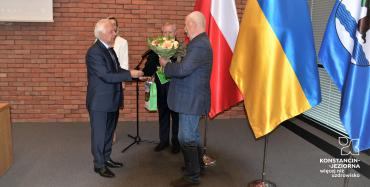 Burmistrz wręcza kwiaty laureatowi